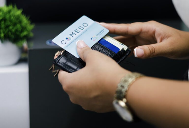 COMESO NFC Karte mit Logo in der Hand mit Geldbeutel zu sehen